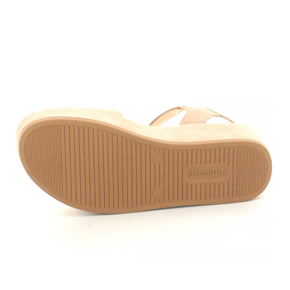 Bottom view of a single blush platform ankle strap sandal with a ridged rubber sole, featuring Remonte&#39;s &quot;Lite ‘n Soft&quot; technology and the brand &quot;Remonte&quot; embossed in the center.