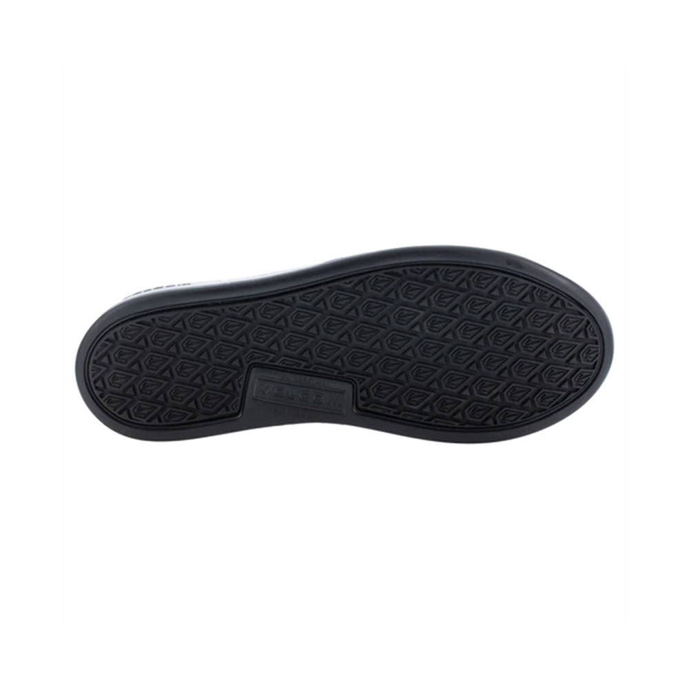 The image shows the sole of a black VOLCOM CHILL COMPOSITE TOE SLIP ON WORK SHOE BLACK - WOMENS by Volcom with a textured pattern, featuring a rectangular logo in the center and slip-resistant outsoles.