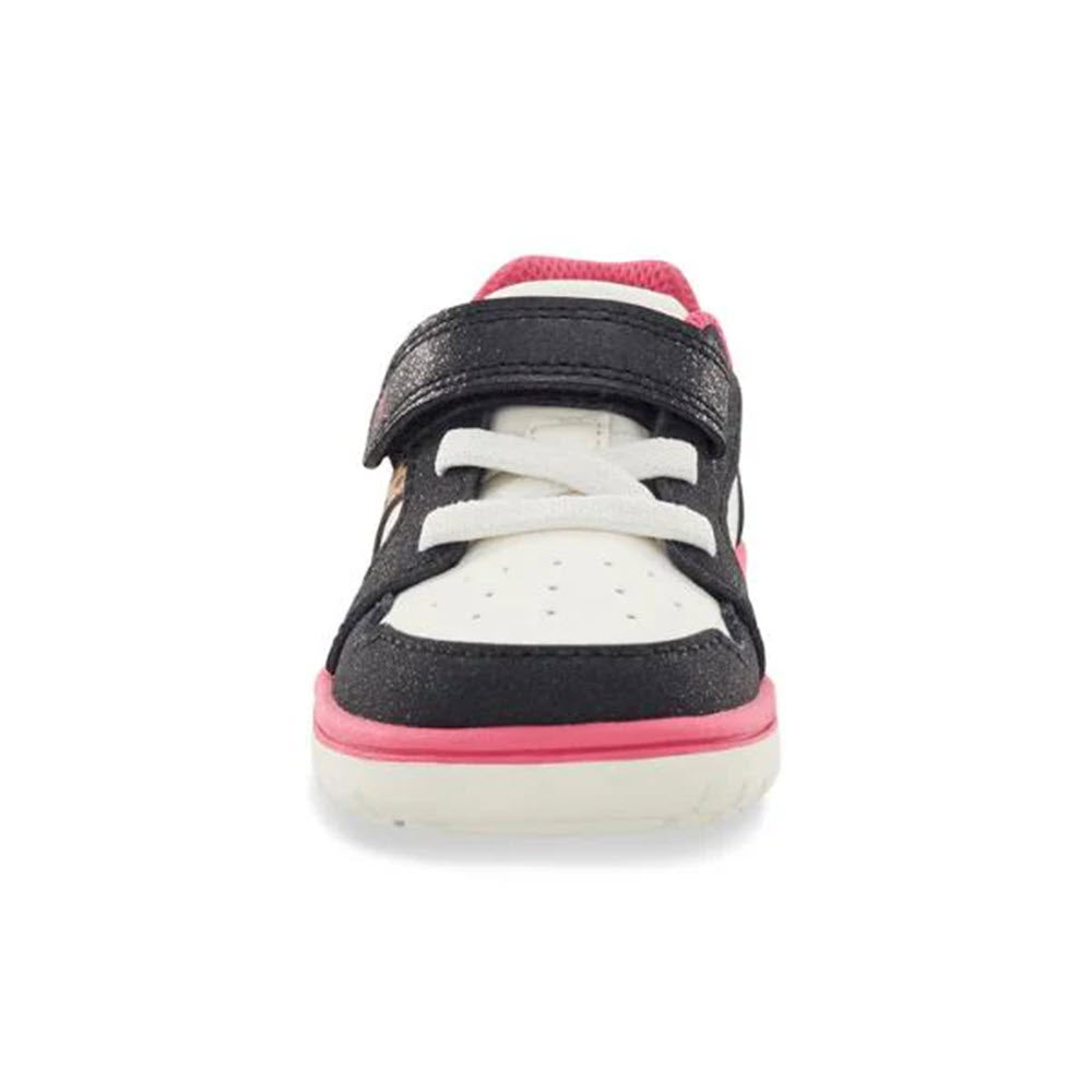 A front view of the Stride Rite SRT London Leopard - Kids athletic shoe, featuring a black and white design with pink trim, a Velcro strap, and white laces on a white background. The shoe provides optimal traction for enhanced stability during play.