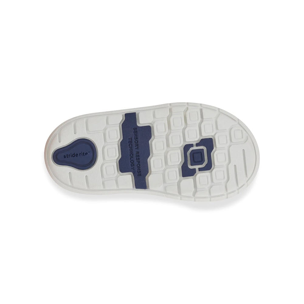 A bottom view of the Stride Rite SRT London Taupe - Kids shoe sole, showcasing a white base with a blue label that reads &quot;Step in Refined Tech,&quot; complemented by hexagonal and rectangular patterns.