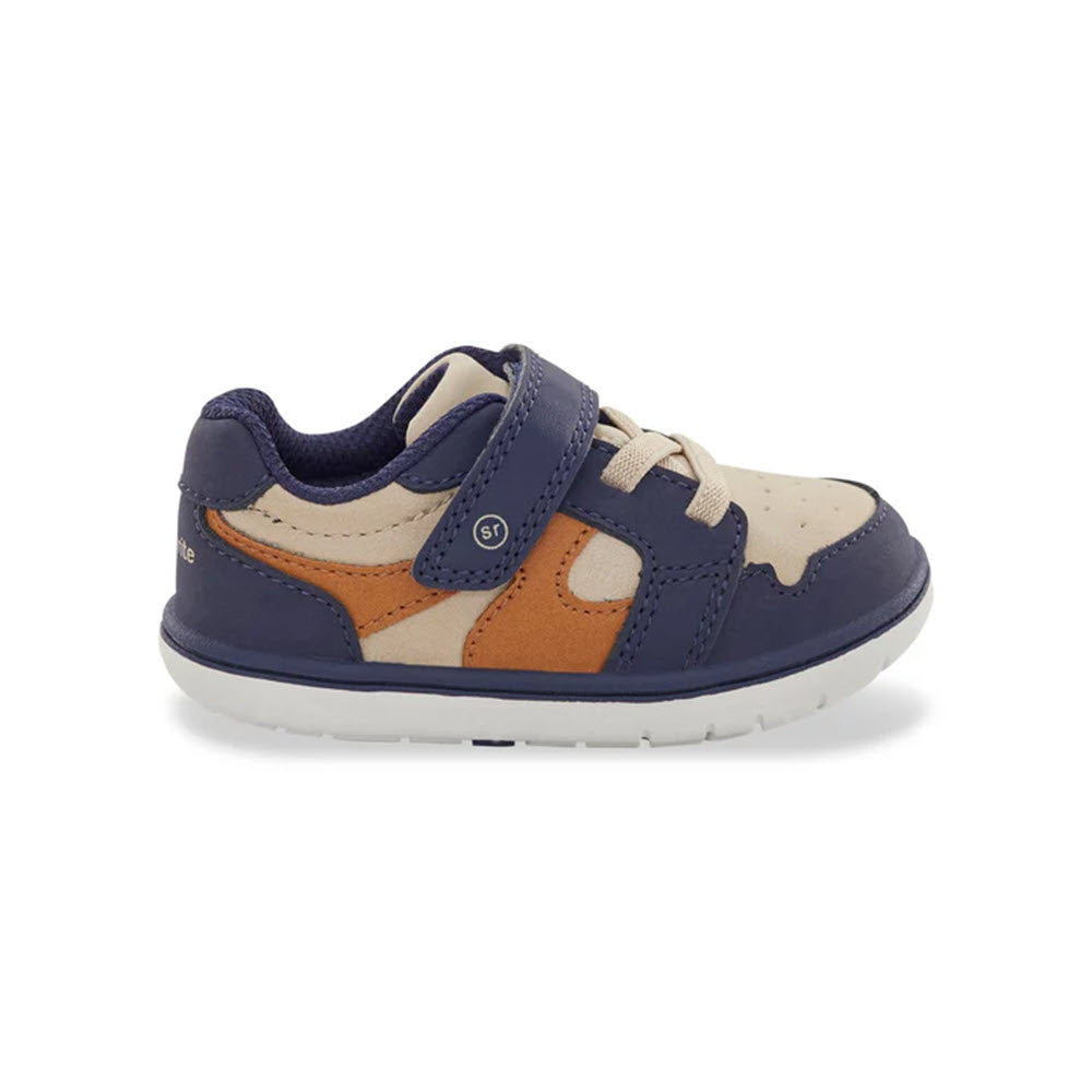 Introducing the Stride Rite SRT London Taupe for Kids, a stylish children&#39;s sneaker with a navy blue and tan design. This shoe features a single Velcro strap, white sole, and breathable fabric. It also incorporates the advanced SRtech sole to ensure added comfort and support.