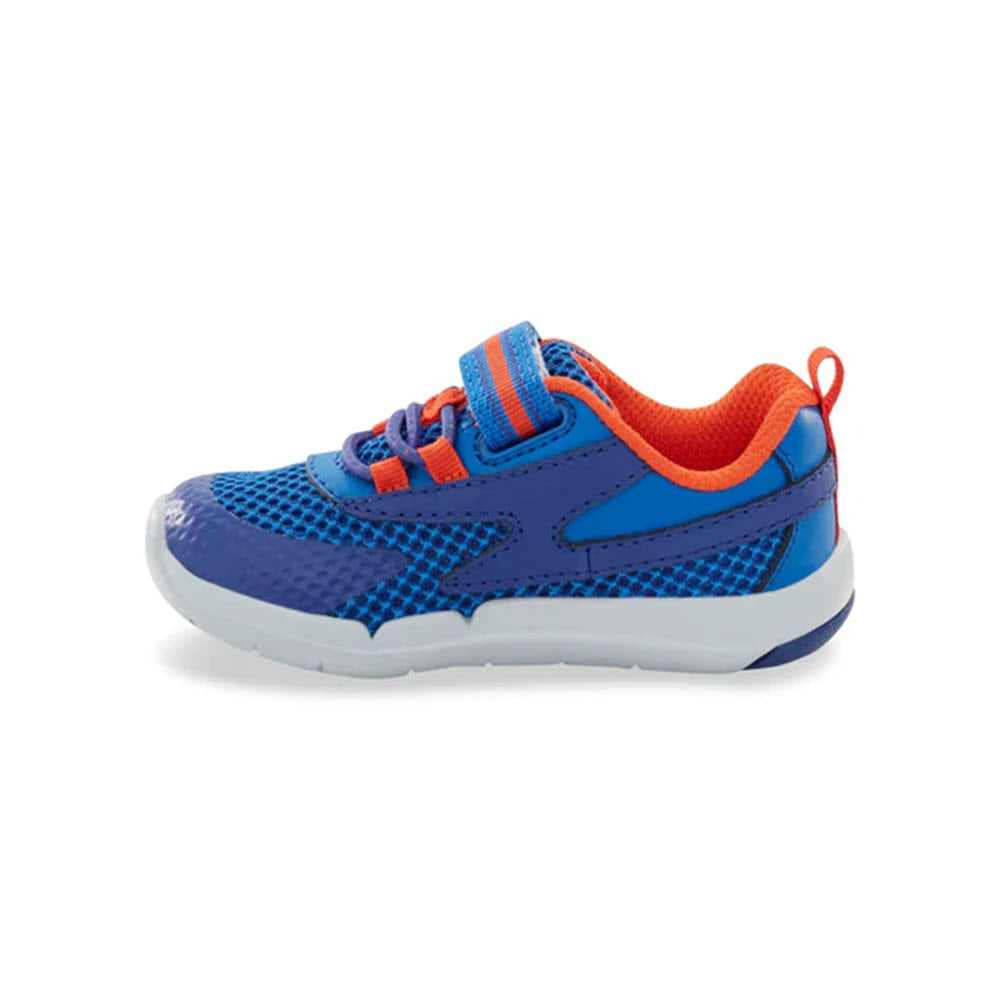 Presenting the STRIDE RITE SRT IAN BLUE - KIDS by Stride Rite: A child&#39;s athletic shoe in blue with orange accents, featuring a Velcro strap, a white rubber sole, and a memory foam footbed for added comfort.