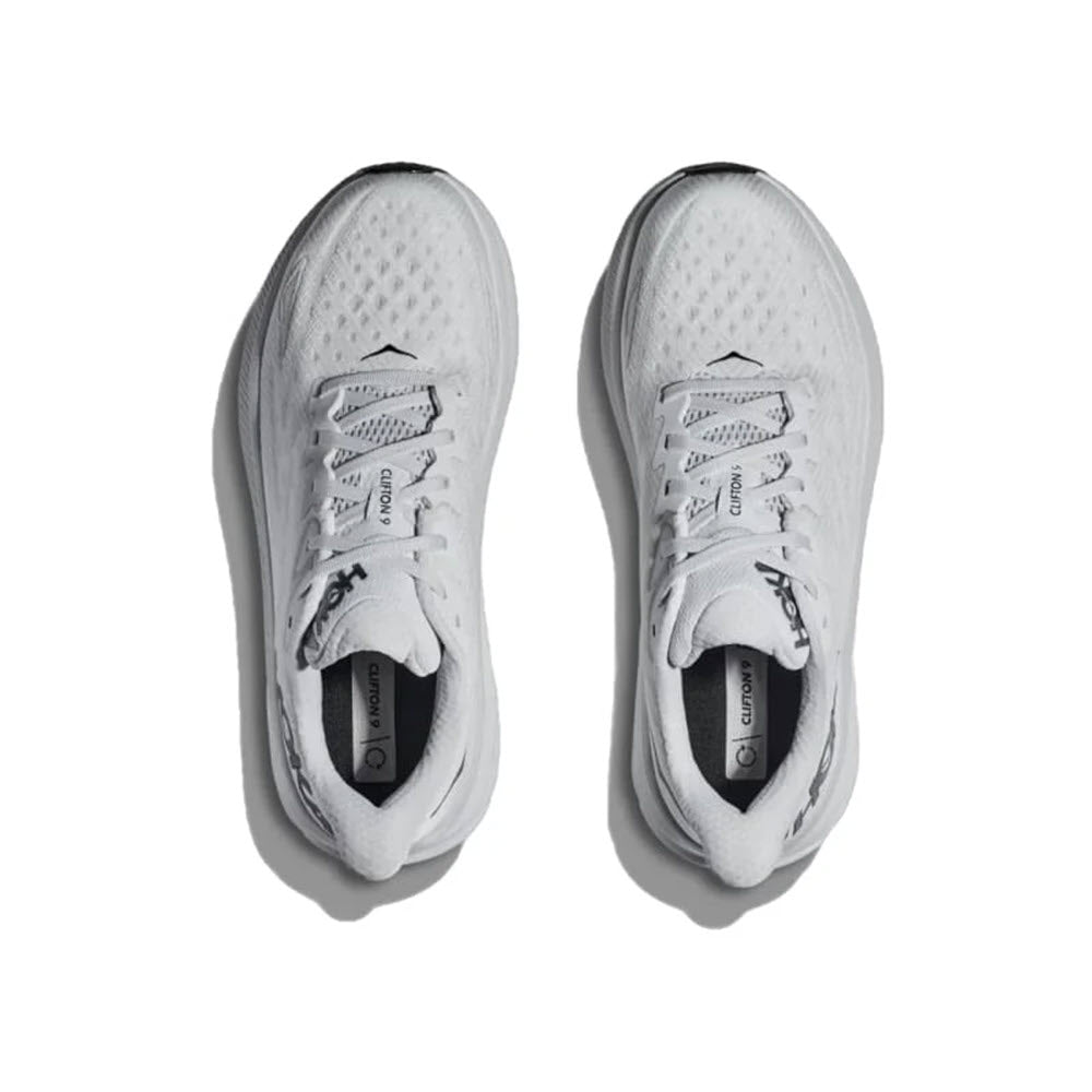 Top view of a pair of Hoka Clifton 9 Nimbus Cloud/Steel Wool men&#39;s running shoes with laces, featuring mesh uppers and thick, cushioned soles made with responsive foam, positioned side by side on a white background.