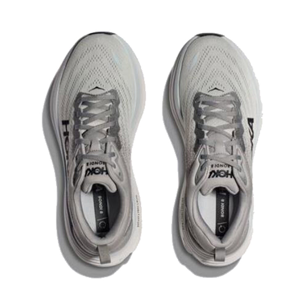 Top view of the HOKA Bondi 8 Sharkskin/Harbor Mist men&#39;s athletic running shoes, featuring a white design with grey accents and laces. The brand name &quot;Hoka&quot; is visible on the sides and inner soles, highlighting their softer lighter foams and extended heel geometry for enhanced comfort.