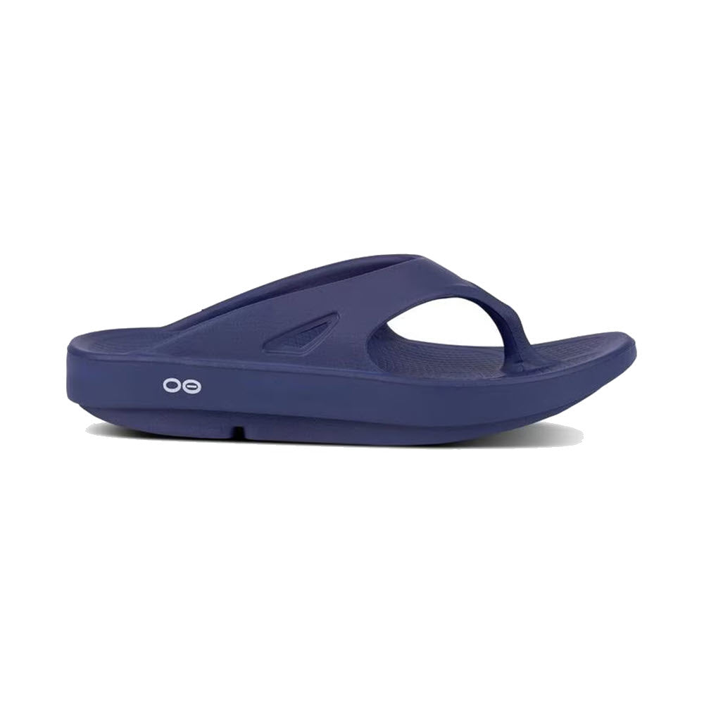 The Oofos OORIGINAL THONG is a blue sandal with a thick sole, featuring OOfoam technology and a toe thong for added comfort. A small white logo adorns the side, emphasizing its Recovery Technology designed to enhance foot support.