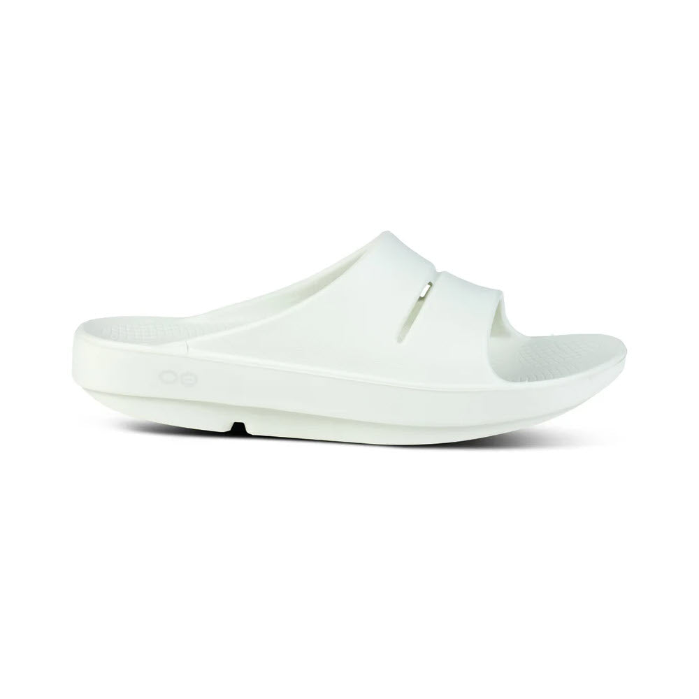 A side view of a single white slide sandal with a thick sole and open-toe design, featuring OOfoam technology for cushioned comfort. Introducing the OOFOS OOAHH COSMIC GRAY - MENS by Oofos.