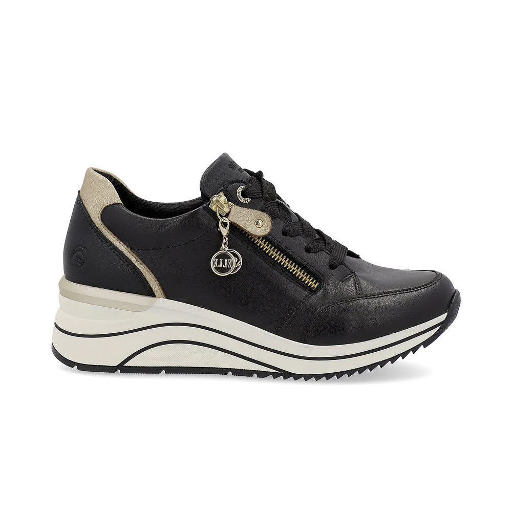 The REMONTE WEDGE SNEAKER WITH ZIP BLACK/GOLD for women, designed by Remonte, features a side zipper, lace-up closure, and platform sole. These black wedge sneakers with beige accents incorporate Lite &#39;n Soft technology for added comfort and come with a small circular keychain displaying the brand logo attached to the zipper.