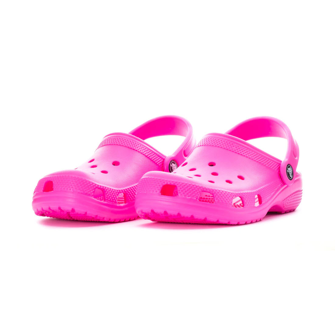 A pair of Crocs Classic Clog Pink Crush - Kids, by Crocs, showcasing bright pink color with ventilation holes and adjustable heel straps, displayed on a white background.