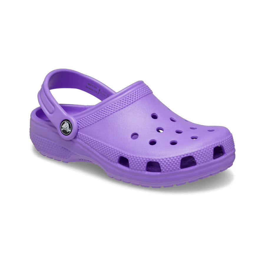 Introducing the CROCS CLASSIC CLOG GALAXY - KIDS by Crocs: a single purple rubber clog featuring ventilation holes, an adjustable strap, a textured sole, and crafted from Croslite material.