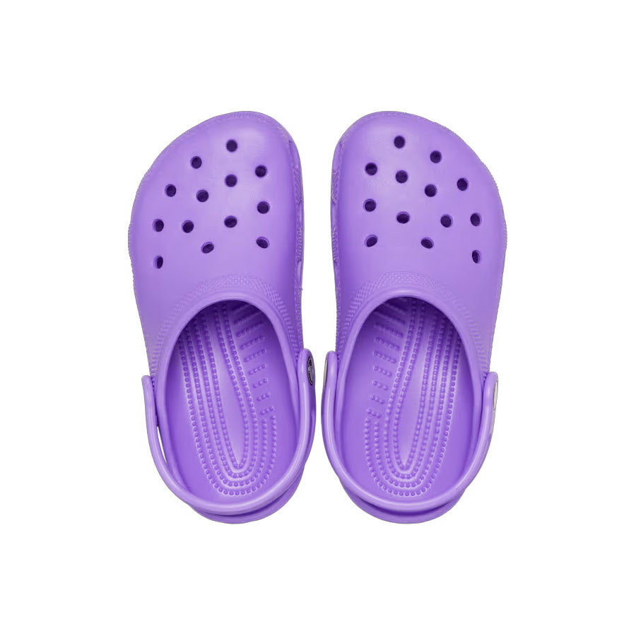 A pair of purple Crocs Classic Clog Galaxy Kids&#39; rubber clogs featuring perforated tops, adjustable heel straps, and a molded design made from Croslite material.