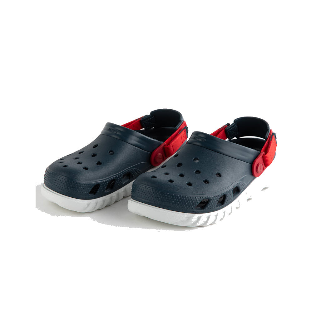 A pair of CROCS DUET MAX II NIGHTFALL - KIDS from Crocs, featuring black slip-on clogs with white soles and red adjustable straps for a customizable fit and durable Croslite comfort, presented against a white background.