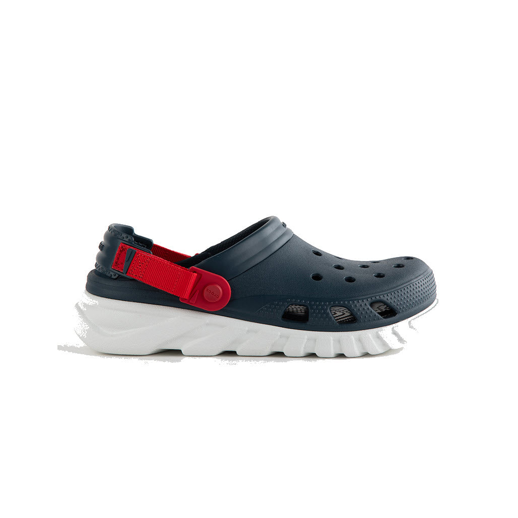 Side view of the CROCS DUET MAX II NIGHTFALL - KIDS by Crocs, showcasing a dark grey clog with a white sole and an adjustable red strap for a customizable fit. The design features ventilation holes on the top and sides to ensure Croslite comfort.