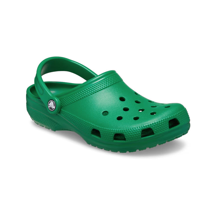 A lightweight green ivy rubber clog, featuring a ventilated upper, heel strap, and textured sole—photographed against a white background—highlights the CROCS CLASSIC CLOG GREEN IVY - ADULTS&#39; signature Iconic Crocs Comfort.