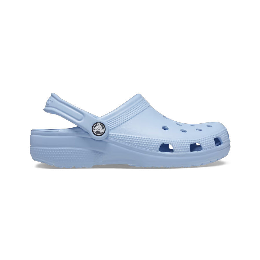 A Crocs Classic Clog in Blue Calcite, featuring a strap and ventilated holes, is displayed against a white background, epitomizing the comfort shoe.