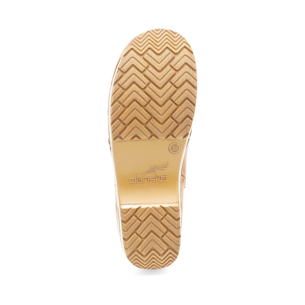 The underside of a Dansko Sigourney Honey Distressed - Womens shoe in tan showcases a zigzag pattern on the sole with a central logo. This cold weather favorite classic stapled clog ensures both style and comfort.