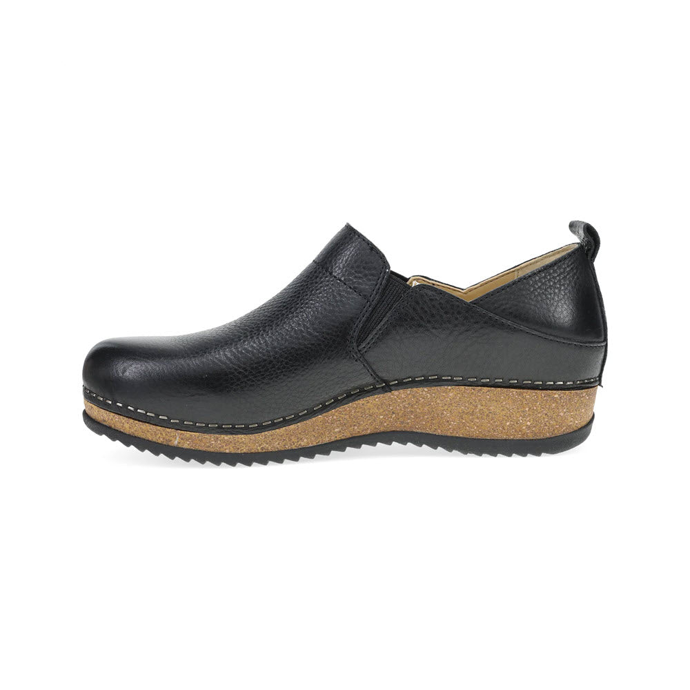 A side view of the DANSKO MEARA BLACK - WOMENS shoe by Dansko, showcasing a black leather casual slip-on design with a cork-textured sole and slight heel. The shoe features intricate stitching details, a convenient loop at the back for easy wearing, and unmatched comfort, making it perfect for anytime, anywhere.