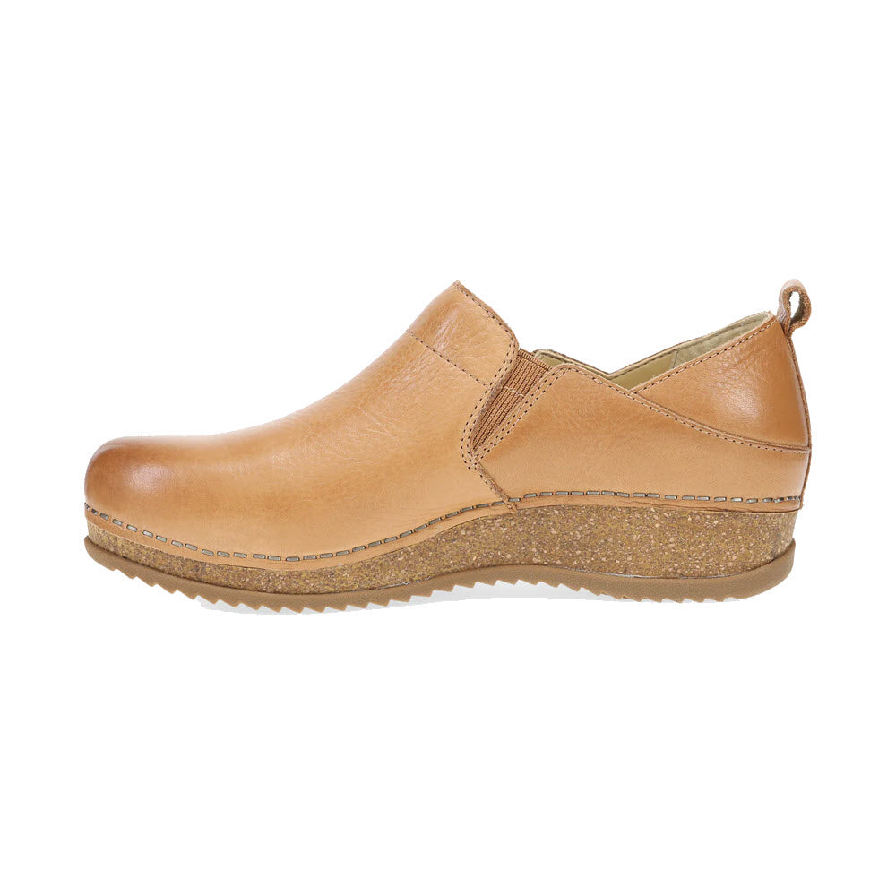 Introducing the DANSKO MEARA TAN - WOMENS by Dansko: a casual slip-on leather shoe in tan, featuring a textured rubber sole and small heel. Designed with a convenient pull tab at the back, it effortlessly combines style and comfort.