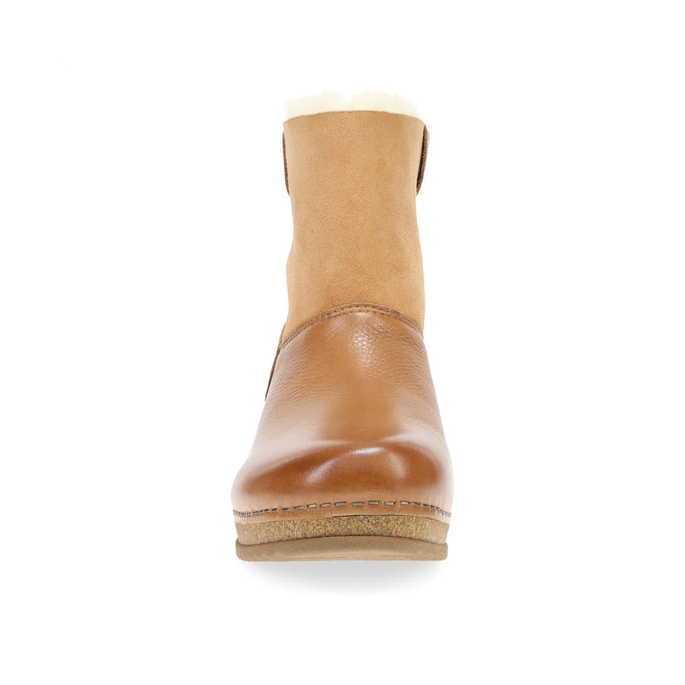 Front view of the Dansko McKenzie Tan women&#39;s winter boot, featuring a shearling-lined shaft and a cork-based sole, set against a white background.