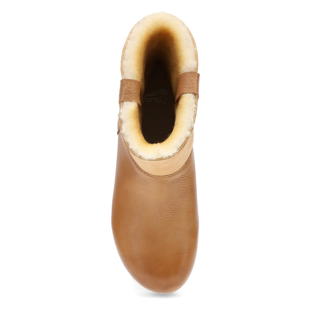 Top view of the Dansko McKenzie Tan women&#39;s ankle boot, showcasing its tan leather design, cork-based soles, and light-colored plush lining, making it a perfect stylish winter boot.