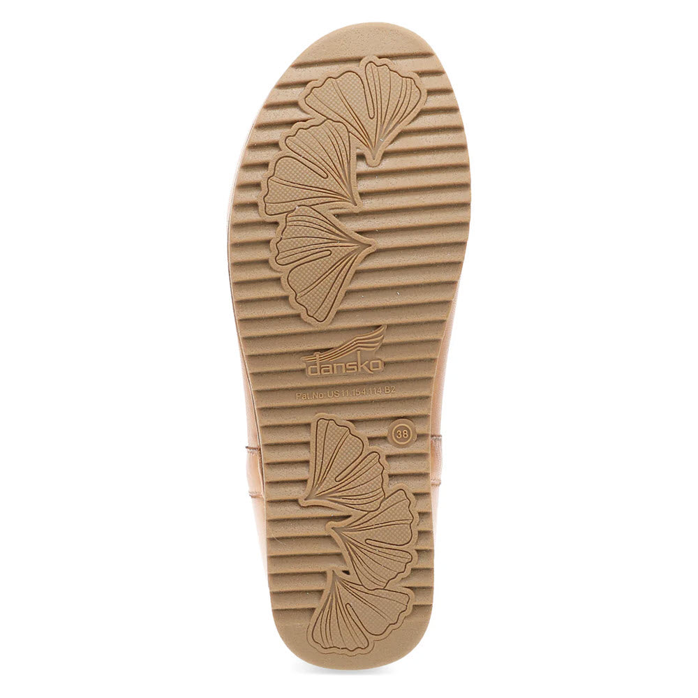 The Dansko McKenzie Tan - Women&#39;s shoe features a sole with engraved leaf patterns and text, complemented by a wavy tread design, making it an ideal winter boot with cozy shearling-lined comfort.