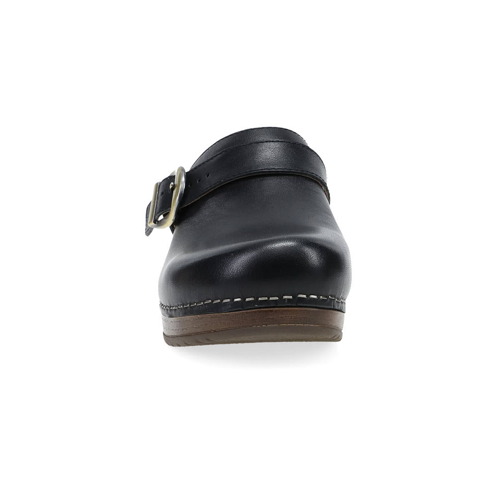 Front view of the DANSKO BAYLOR BLACK - WOMENS, a stylish black clog by Dansko featuring a bold buckle strap and brown sole.