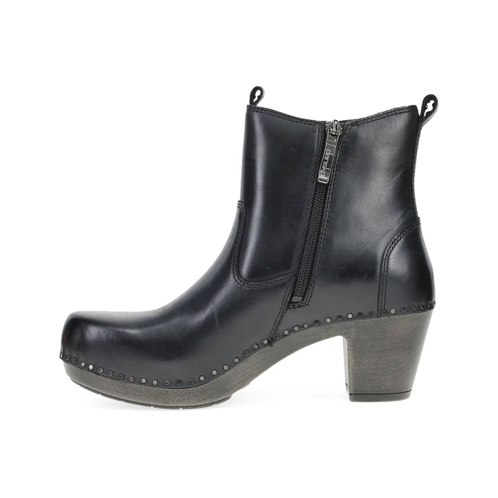 The DANSKO SHAYNA BLACK - WOMENS boot by Dansko is a true fashion statement with its side zipper, rounded toe, and studded accents along the sole. This heeled boot features a chunky, medium-height heel for added flair and comfort.