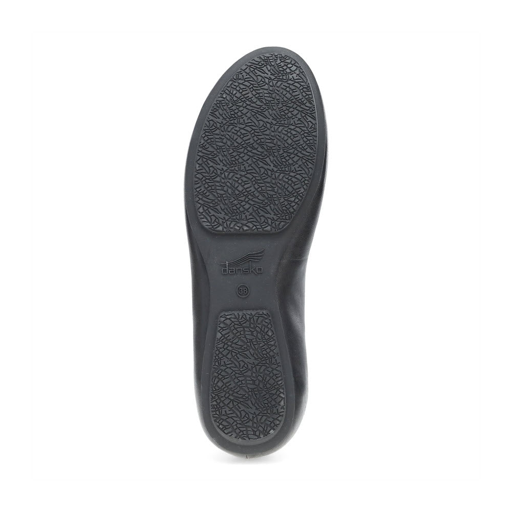 The image showcases the black, textured sole of the Dansko Mollie Black ballet flat for women, featuring a circular logo and the size number 39 in the center, exemplifying chic comfort.