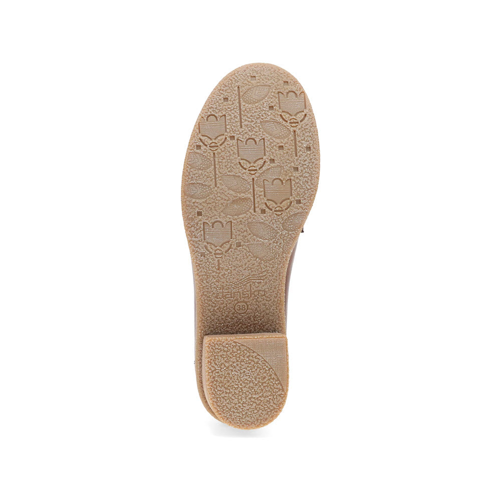 The image showcases the textured sole of the Dansko Danica Tan - Womens chunky loafer, featuring an embossed floral pattern on the bottom.