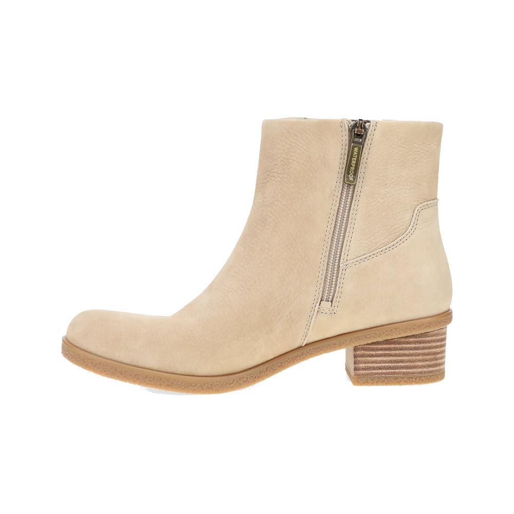 The DANSKO DAISIE SAND - WOMENS features a beige ankle boot design with a side zipper, stacked low heel, and renowned Dansko support for all-day comfort.