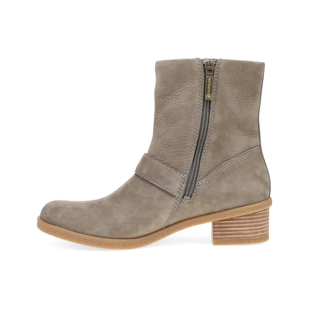 The **Dansko Delphine Stone - Womens** is a grey suede mid-calf moto bootie featuring a side zipper, stylish hardware, and a low wooden heel.