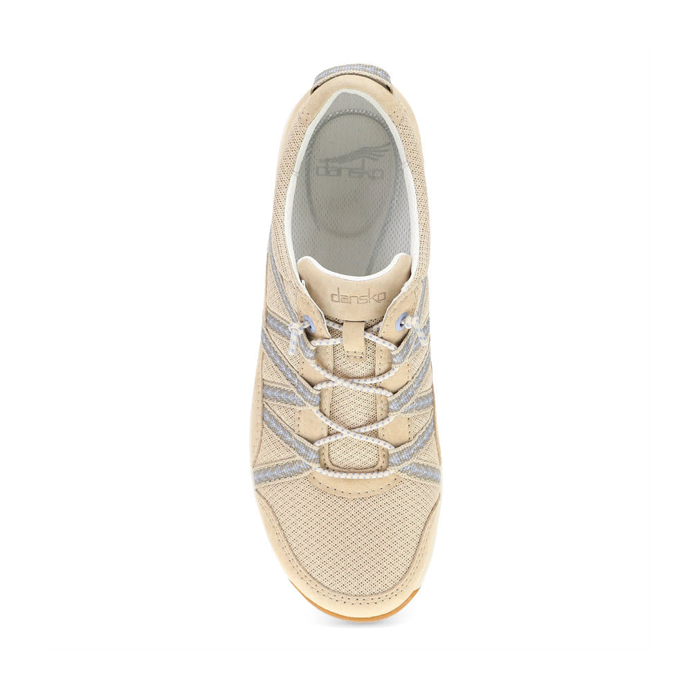 Top view of a beige athletic sneaker with grey accents, white laces, and a mesh design, displaying the &quot;Dansko&quot; brand logo. The DANSKO HARLYN SAND - WOMENS combines premium support with lightweight performance for ultimate comfort.