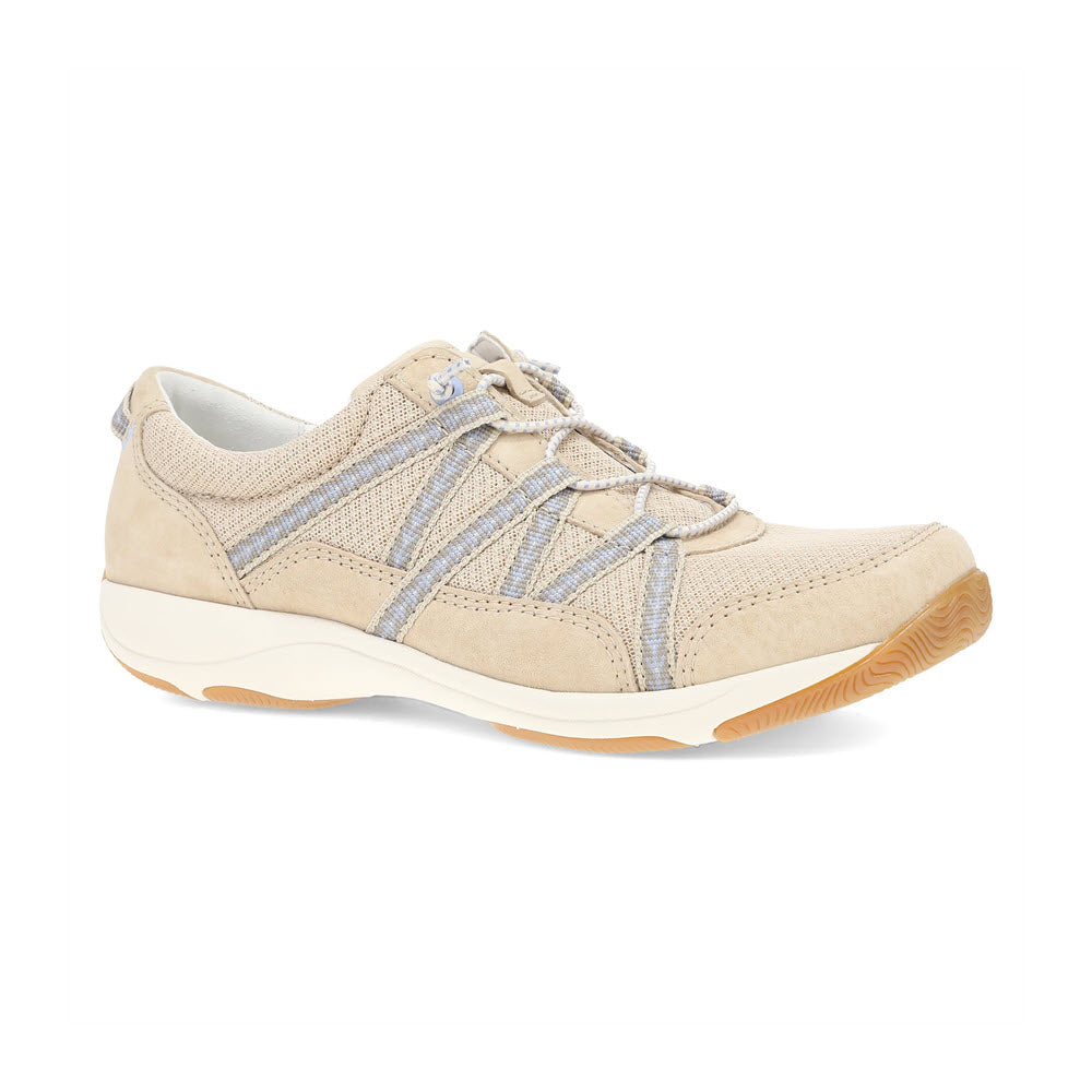 A beige casual sneaker with light blue accents, featuring a rubber outsole and decorative stitching. The shoe has a lace-up front and offers lightweight performance and premium support for optimal comfort. Introducing the DANSKO HARLYN SAND - WOMENS by Dansko.