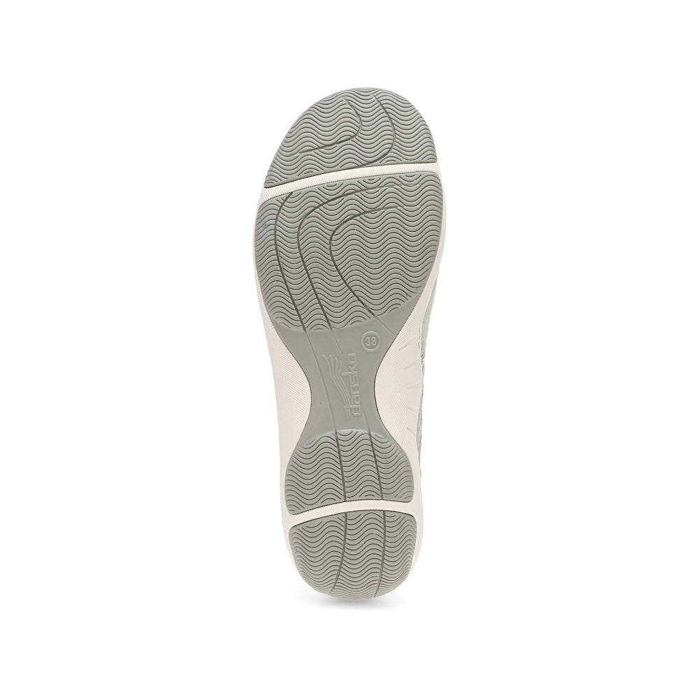 The image shows the sole of a gray sneaker with a textured, non-slip pattern. The brand name &quot;Dansko&quot; is visible in the center of the sole, showcasing its commitment to premium support.