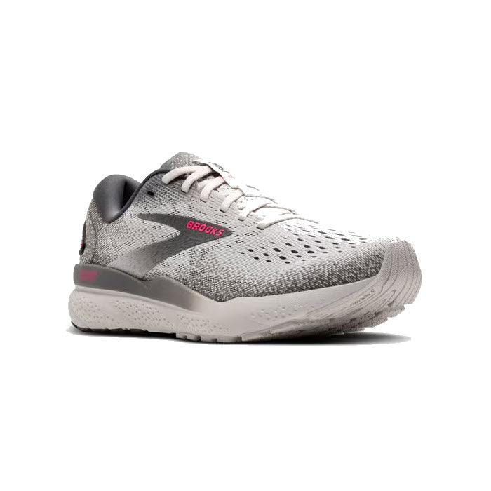 The women&#39;s Brooks Ghost 16 in Grey/Gargoyle/Pink is an athletic running shoe featuring red accents on the side and heel, breathable mesh material, and a cushioned sole for a comfortable fit. It also boasts lightweight cushioning, making it perfect for long runs.