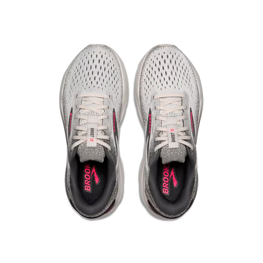 A pair of BROOKS GHOST 16 GREY/GARGOYLE/PINK - WOMENS running shoes, viewed from above. The light gray shoes feature black and pink accents, with tied laces and insoles displaying the &quot;Brooks&quot; brand name in pink. These shoes offer a comfortable fit and lightweight cushioning for an optimal running experience.