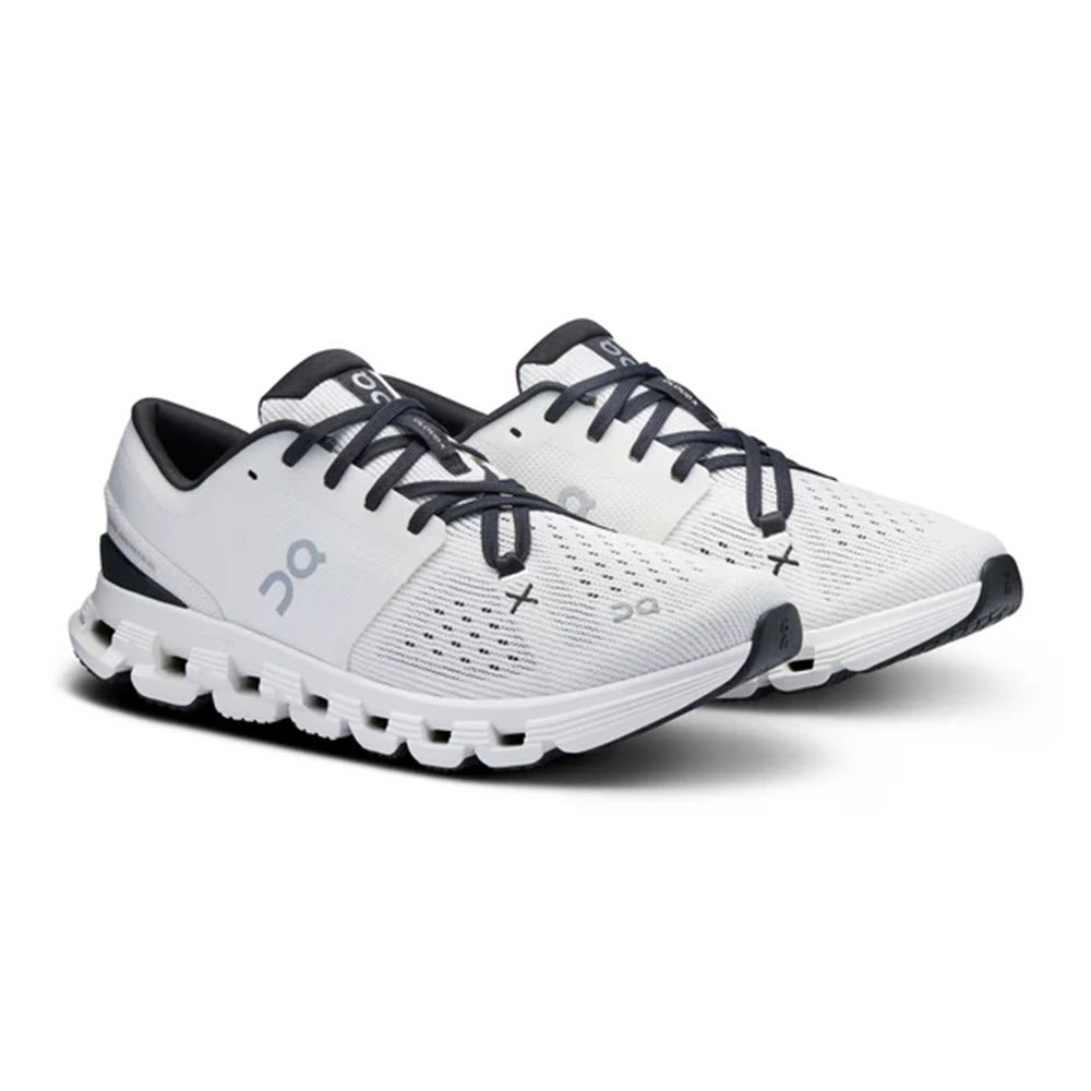 The ON CLOUD X 4 IVORY/BLACK shoes for women by On Running are a pair of white training shoes with black and grey accents, featuring a unique Speedboard design for enhanced forefoot flexibility.