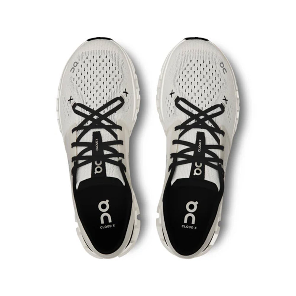 Top view of a pair of ON CLOUD X 4 IVORY/BLACK women&#39;s training shoes from On Running, featuring black laces and black soles. The brand&#39;s logo is prominently displayed on the tongue and insole, showcasing their Speedboard design for enhanced forefoot flexibility.