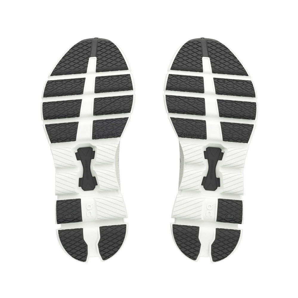 Image of the bottom of a pair of ON CLOUD X 4 IVORY/BLACK - WOMENS training shoe soles from On Running, featuring a white base with black rubber tread sections arranged in a pattern designed for grip and forefoot flexibility, complemented by an advanced Speedboard design.