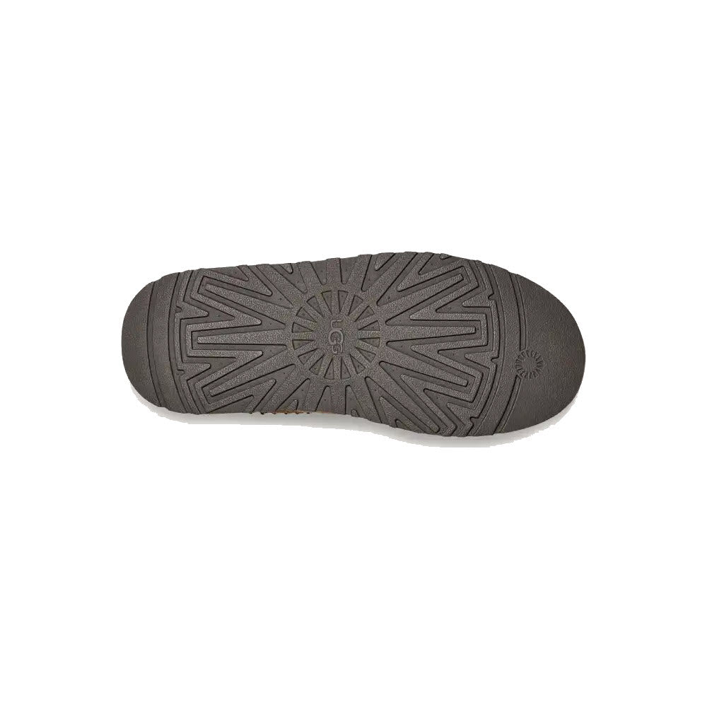 The UGG TAZZ HICKORY - WOMENS by Ugg is a black clog with a circular patterned sole and multiple grooves, featuring a comfortable platform outsole.