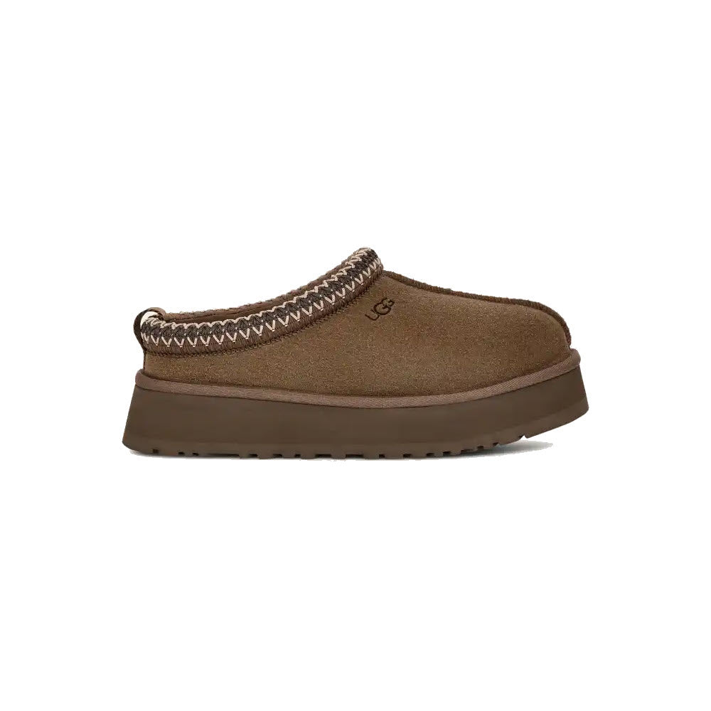 The UGG Tazz Hickory for women by Ugg features a rich brown color, a substantial platform outsole, detailed stitching around the opening, and a cozy UGGplush™ lining.