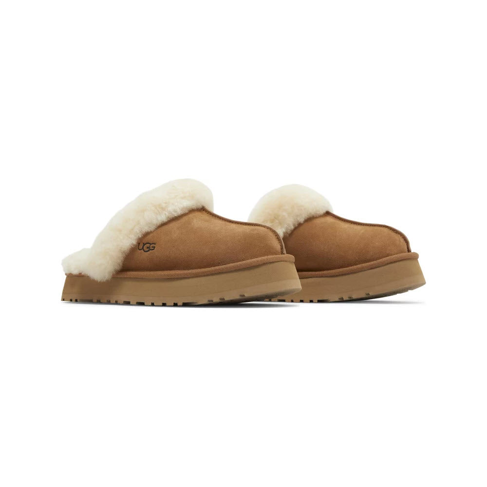 Introducing the UGG Disquette Chestnut for Women by Ugg: a stylish pair of tan suede slippers featuring cozy white fleece lining, convenient low backs, and durable brown rubber soles in a timeless slip-on design.