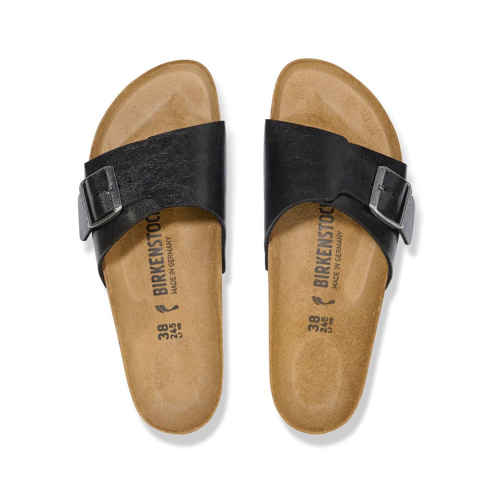 A pair of Birkenstock BIRKENSTOCK CATALINA GRACEFUL LICORICE - WOMENS sandals featuring black Birko-Flor straps with buckle details, and a tan footbed labeled with size and branding information.