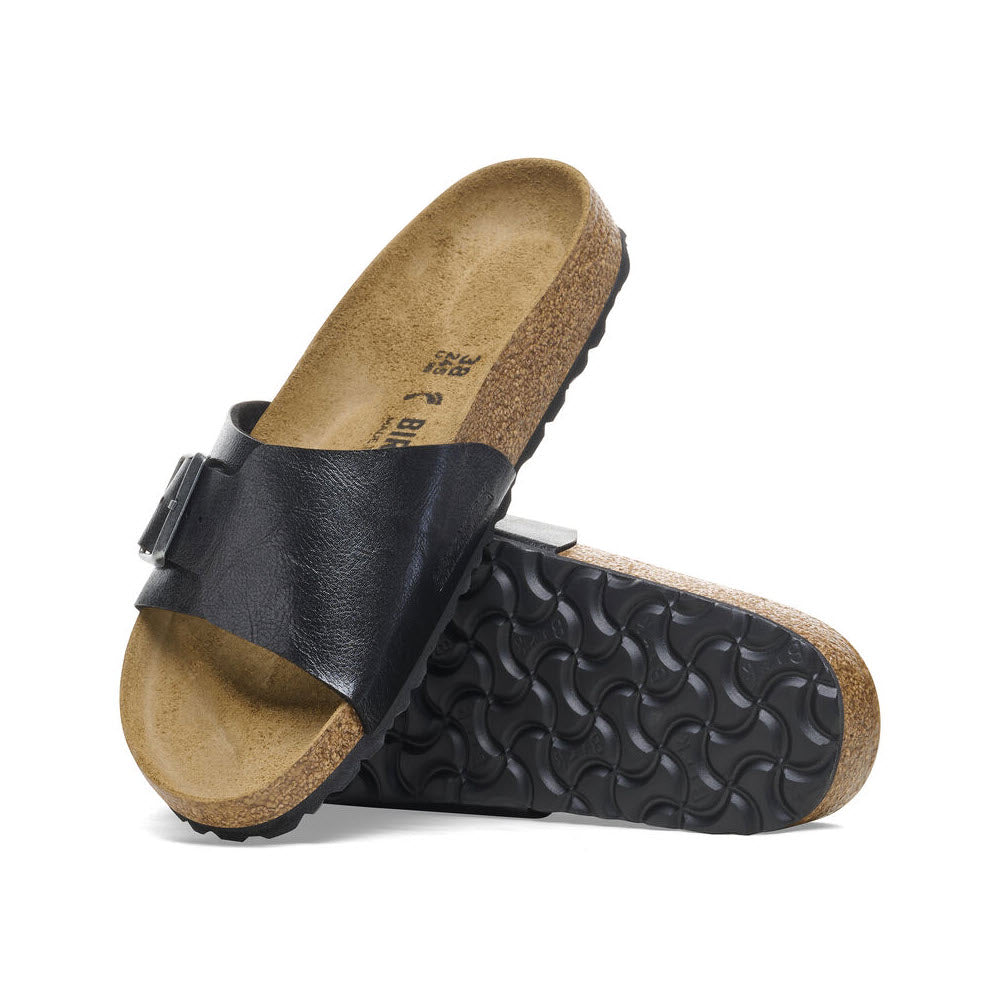 A pair of black single-strap Birko-Flor sandals with cork footbeds and textured rubber soles, displayed with one sandal upright and the other lying down.

Updated sentence: A pair of black single-strap BIRKENSTOCK CATALINA GRACEFUL LICORICE - WOMENS sandals with cork footbeds and textured rubber soles by Birkenstock, displayed with one sandal upright and the other lying down.