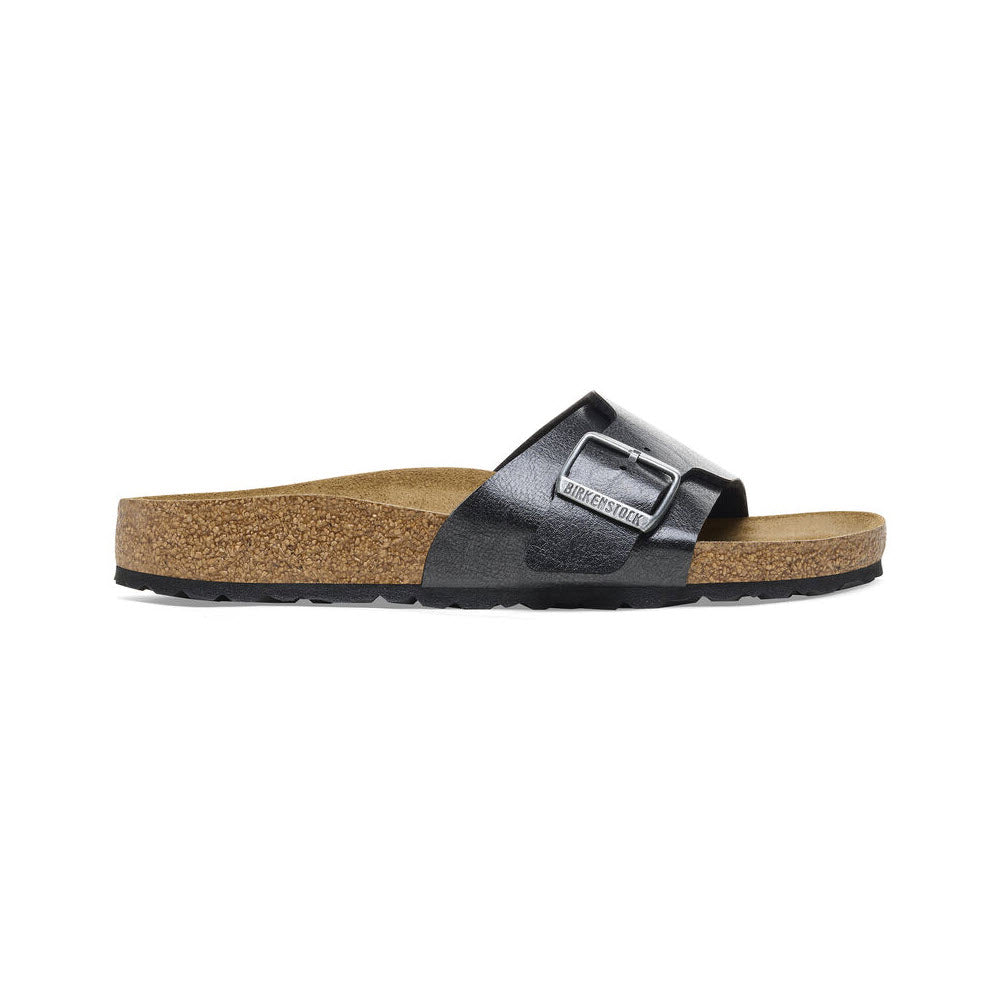 A black Birkenstock BIRKENSTOCK CATALINA GRACEFUL LICORICE - WOMENS with a cork footbed and a single wide strap featuring a metallic buckle, viewed from the side.