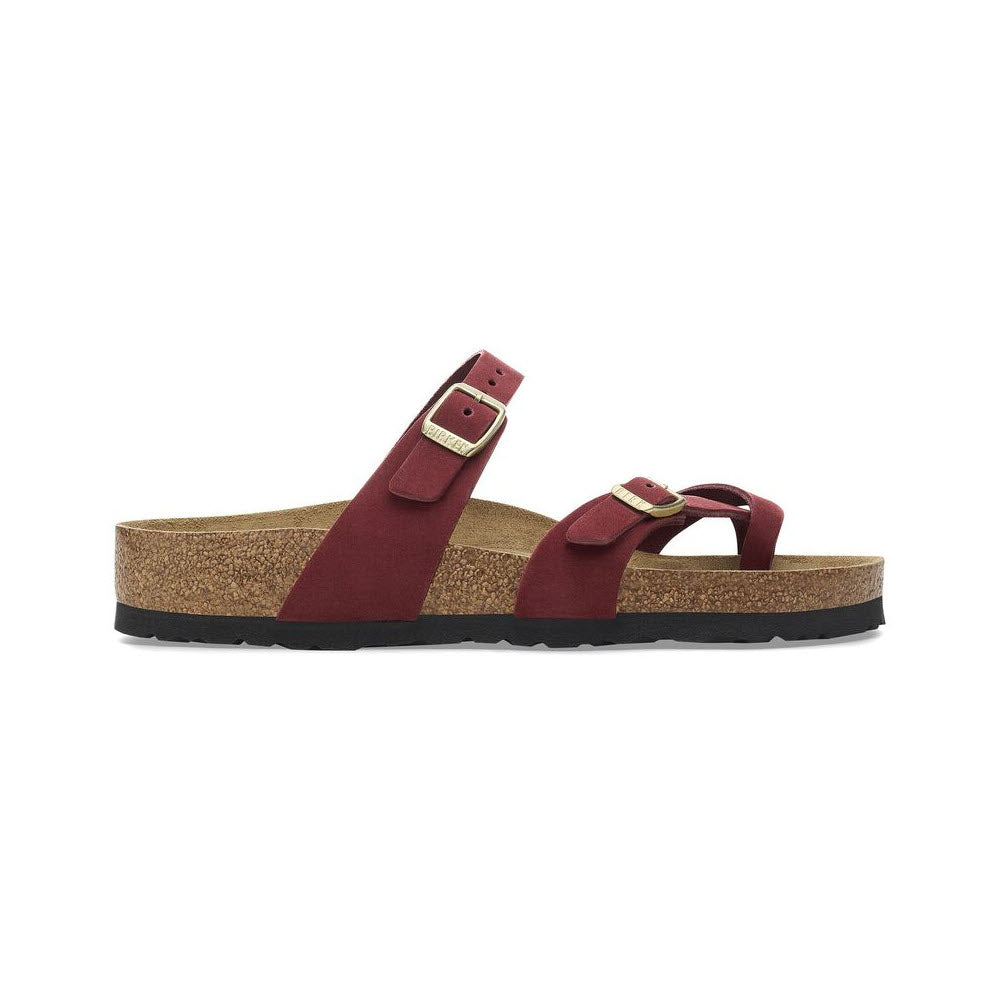 The BIRKENSTOCK MAYARI ZINFANDEL sandals for women, offered by Birkenstock, feature a striking red color with two adjustable straps and a nubuck leather finish. Designed for comfort, they include a cork sole and soft footbed, shown from the side view.