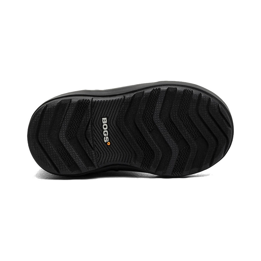 The image displays the black treaded sole of a BOGS CLASSIC II WARPED STRIPES - KIDS shoe, with &quot;BOGS&quot; prominently featured in the center, emphasizing its flexibility and traction engineered for healthy foot growth.