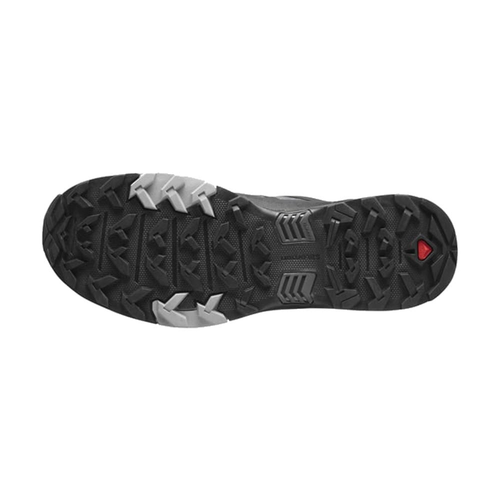 The sole of the SALOMON X ULTRA 4 MAGNET/BLACK/MONUMENT hiking shoe for men by Salomon features rugged tread patterns with grey accents, a small red triangle near the heel, and the advanced Contagrip® sole system for superior grip.