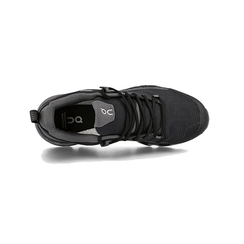 Top view of the ON CLOUDWANDER WATERPROOF BLACK/ECLIPSE - WOMENS, an athletic, lightweight, and agile shoe from On Running, in black with black laces and a grey tongue featuring the &quot;ON&quot; logo inside.