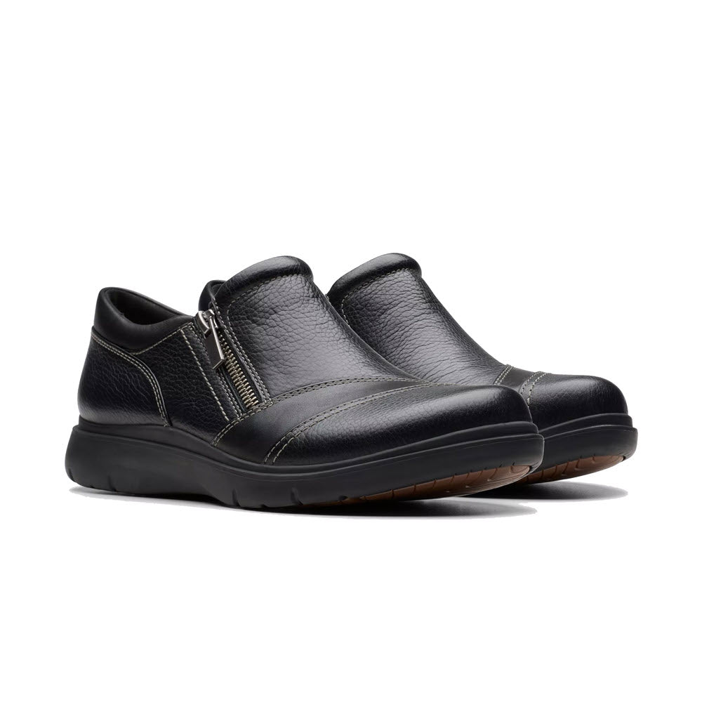 Introducing the Clarks Certina Pure Black - Women&#39;s shoes: a pair of black leather slip-ons featuring side zippers and brown soles, crafted from premium materials for unmatched comfort.