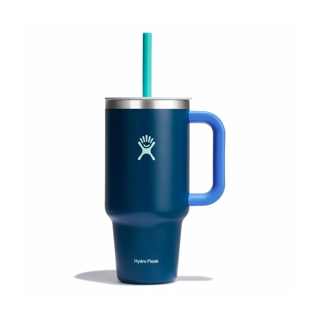 A blue 32oz Hydro Flask Travel Tumbler from the Winter Night collection is showcased elegantly against a white background, complete with a handle and teal straw. Its leak-resistant design ensures your drink remains secure, making it ideal for travel enthusiasts.